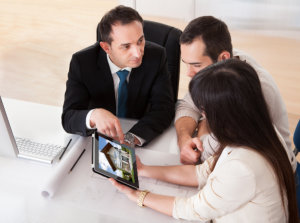 couple choosing a house using a tablet with a realtor